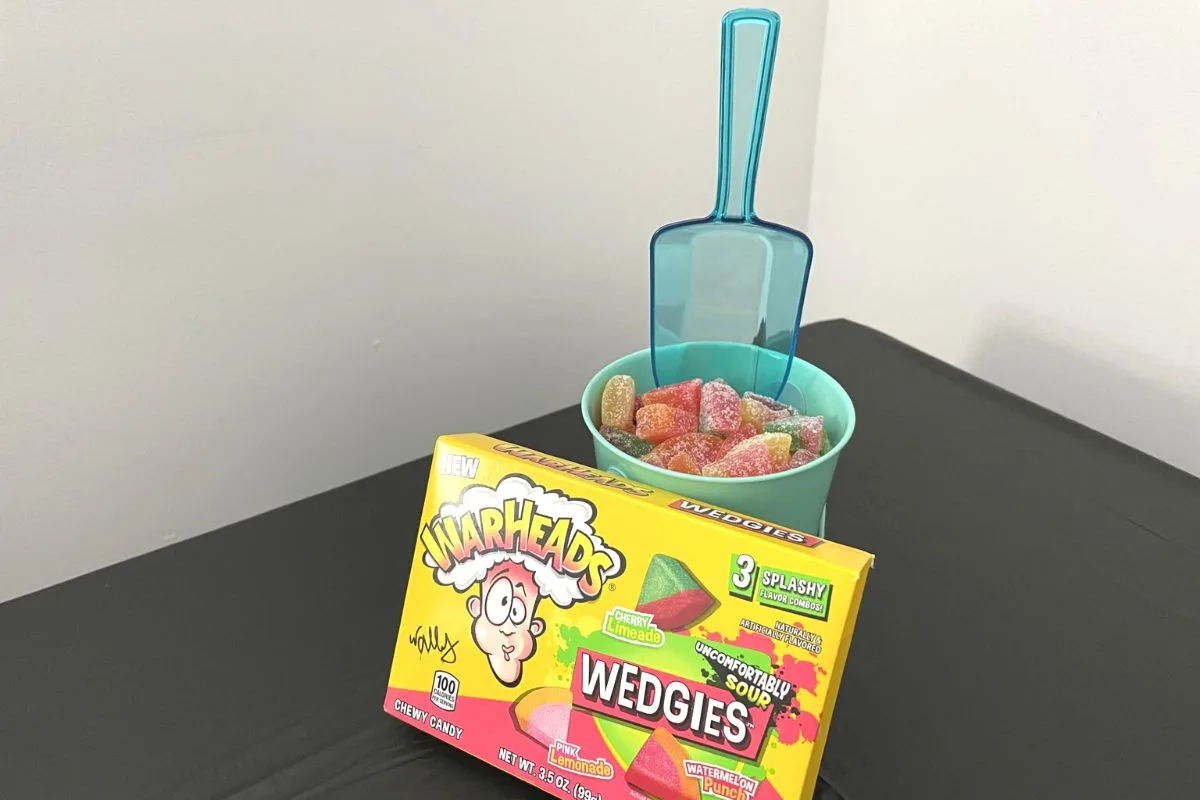 teal tin bucket with teal scoop, filled with warheads candy