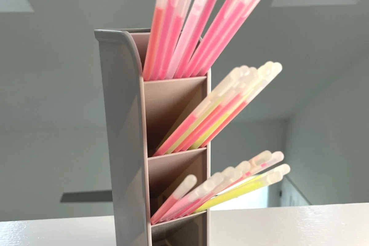 gray pencil holder, standing vertically, filled with glow sticks