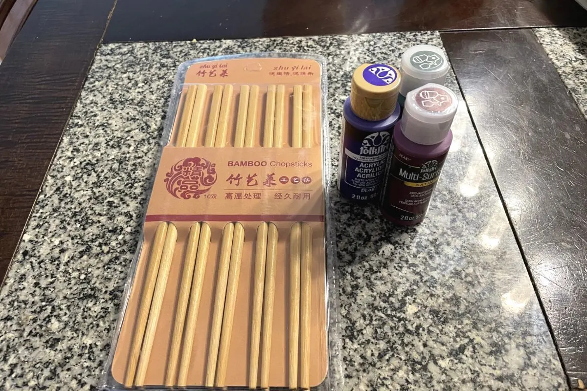 bamboo chopsticks package and three kinds of paint on a dark table
