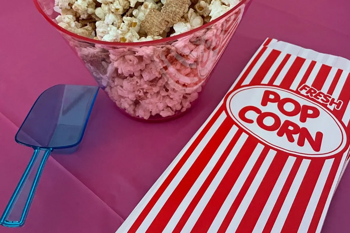 popcorn with cinnamon toast crunch in bucket next to scoop and popcorn bag