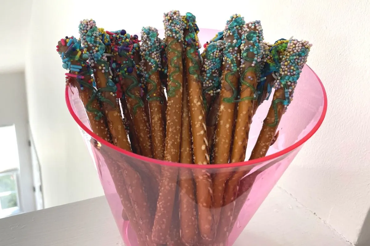 bucket of chocolate and sprinkle covered pretzel rods to sell at market day