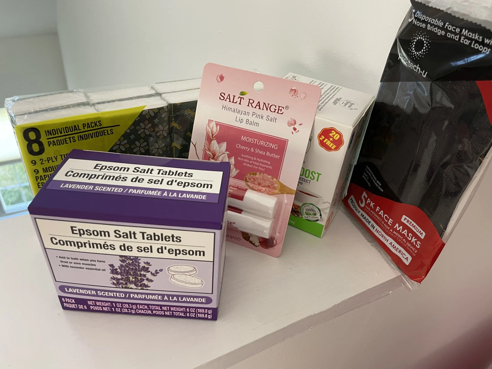 cold kit items on white background, including face masks, epsom salt tablets, tissue packages, etc.