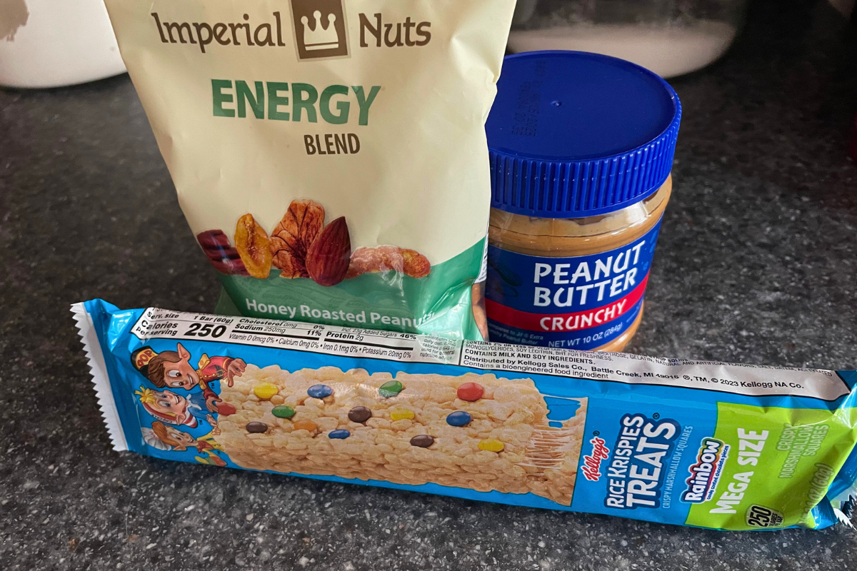 Jar of Crunchy peanut butter, Mega Size Rainbow Rice Krispies Treats, and nuts blend