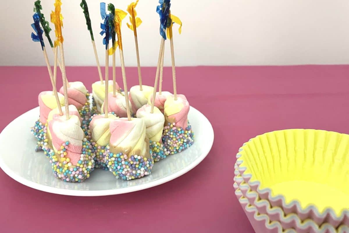 sprinkled covered rainbow marshmallows and cupcake liners on market day table to sell