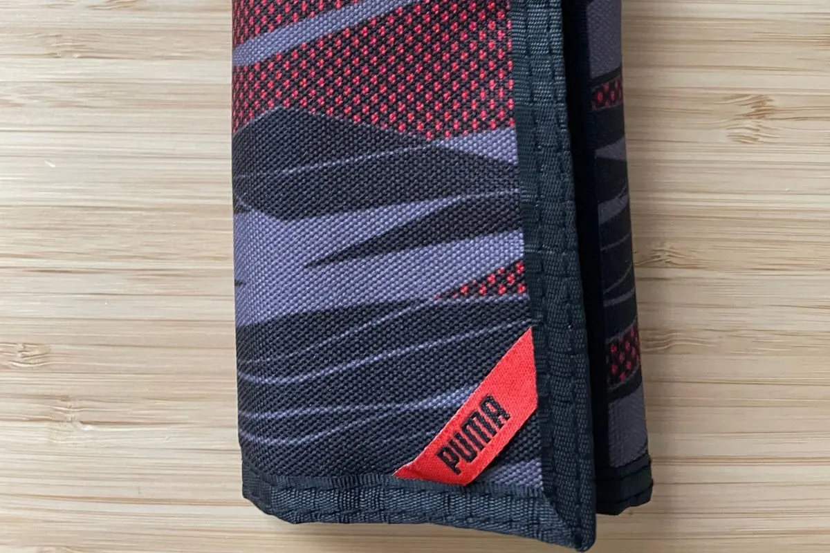 red, black, and charcoal striped Puma wallet
