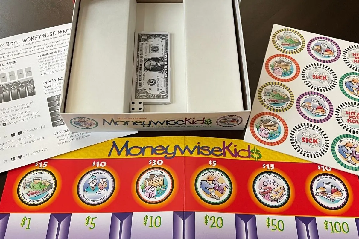 red, yellow, and purple MoneyWise Kids board game on dark table