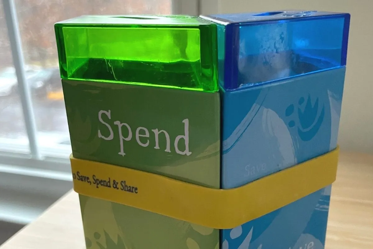 green, blue, and red slotted containers all together with yellow band on desk