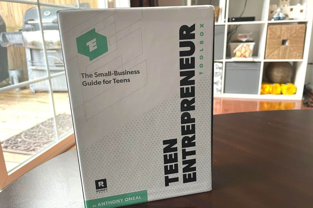 white, sleek-looking Teen Entrepreneur Toolbox standing up on dark table