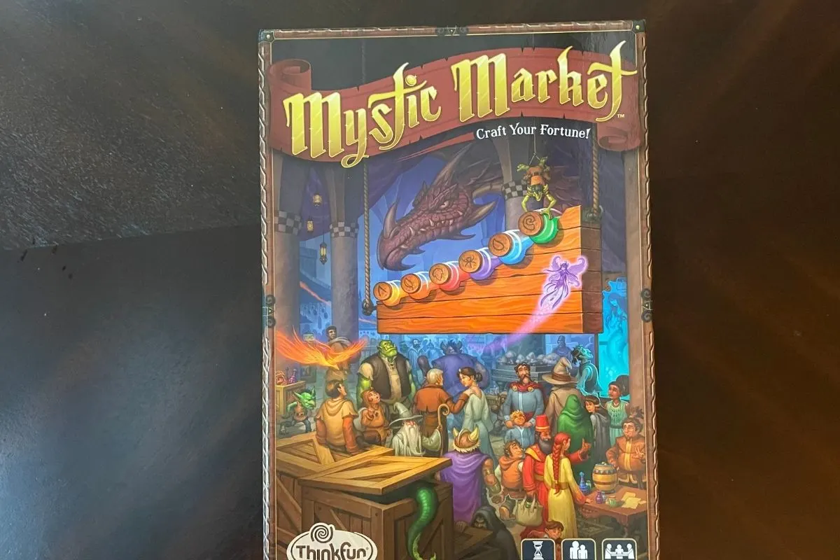 Mystic Market cover with marketplace and dragon on it, on dark table