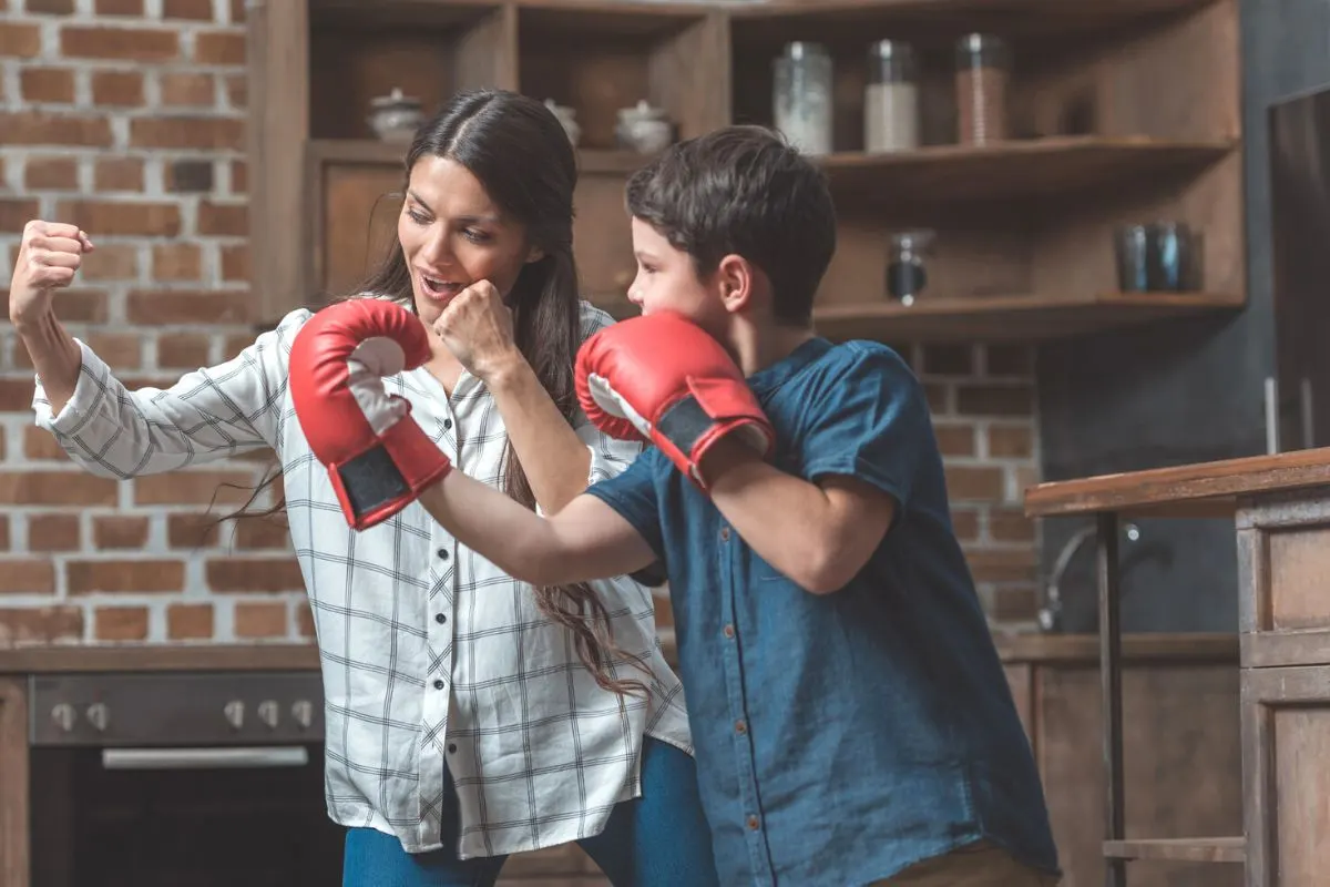 mother and son practicing boxing with boxing gloves at home for tuck-in time