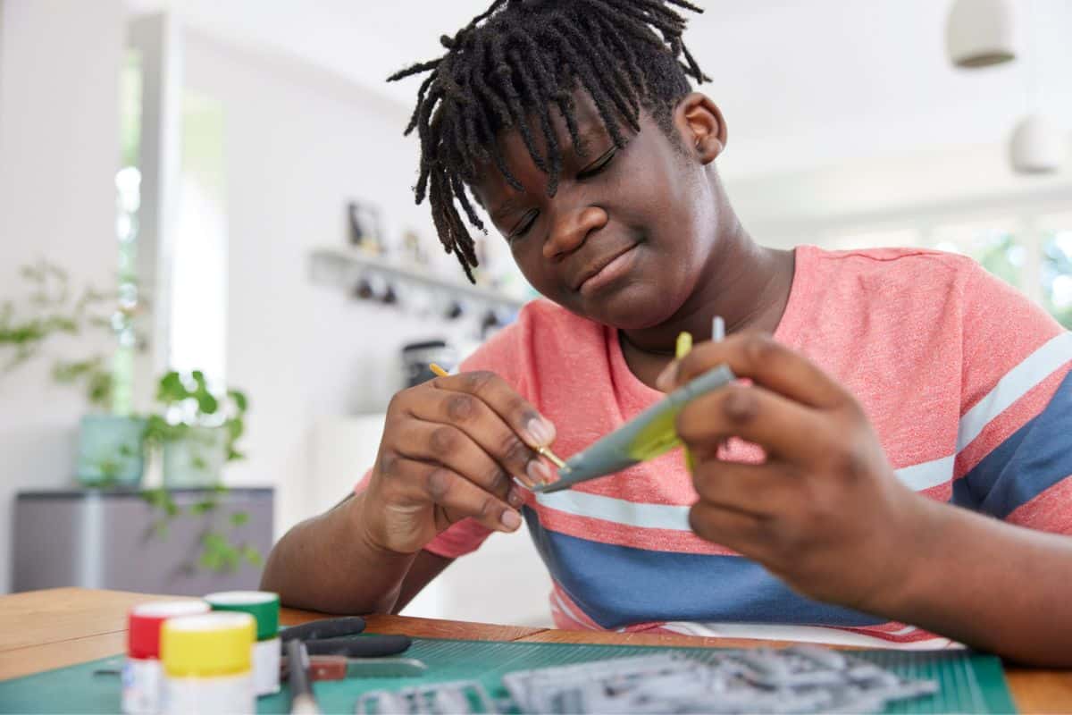 tween boy working on airplane craft to sell