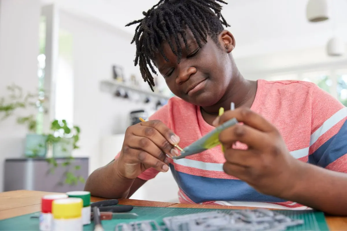 tween boy working on airplane craft to sell