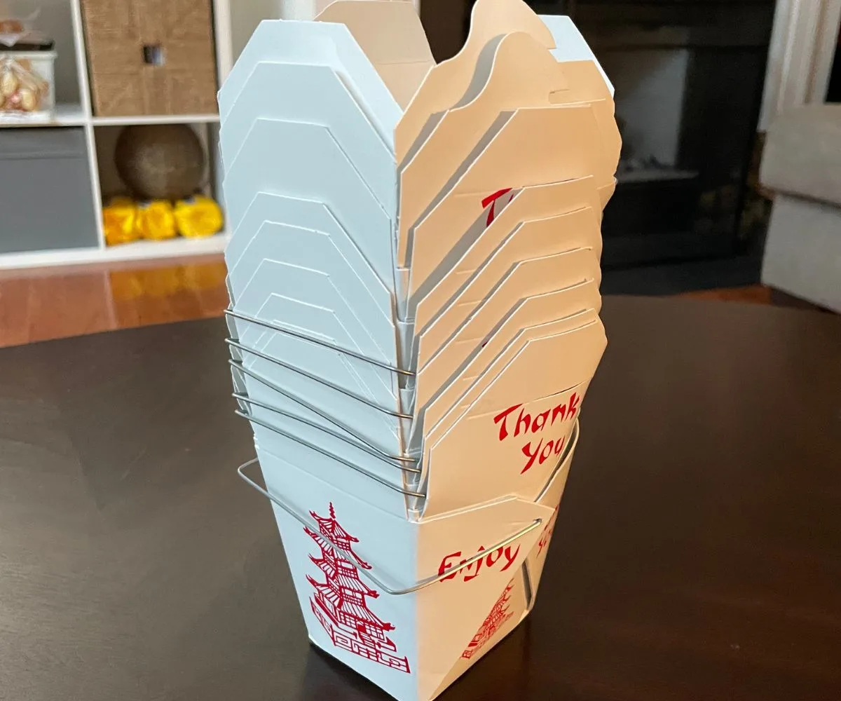 stack of Chinese takeout boxes on dark table