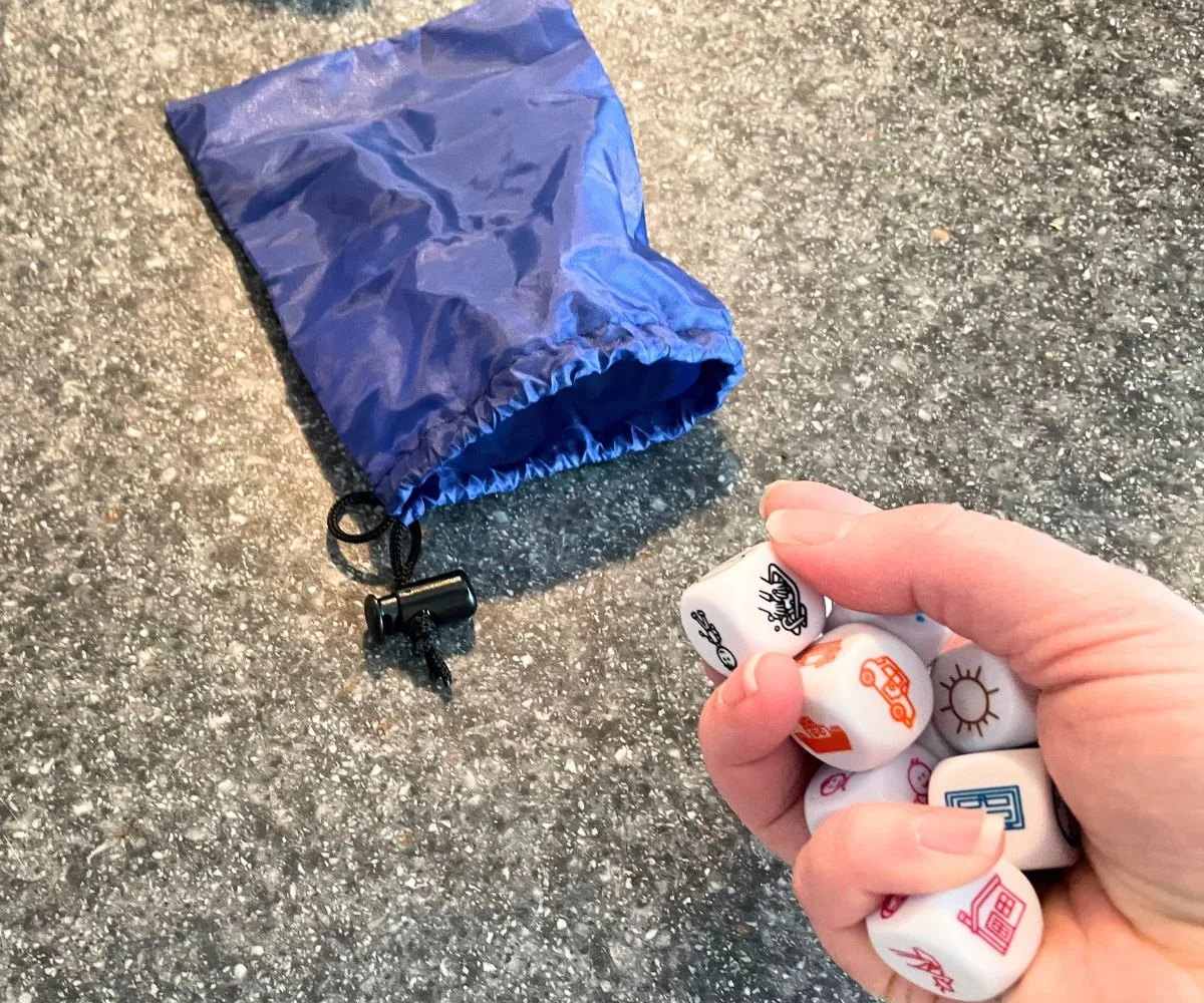 girl with handful of story dice about to throw them on counter