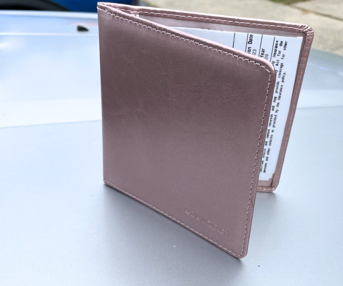 metallic pink car document holder on top of car hood