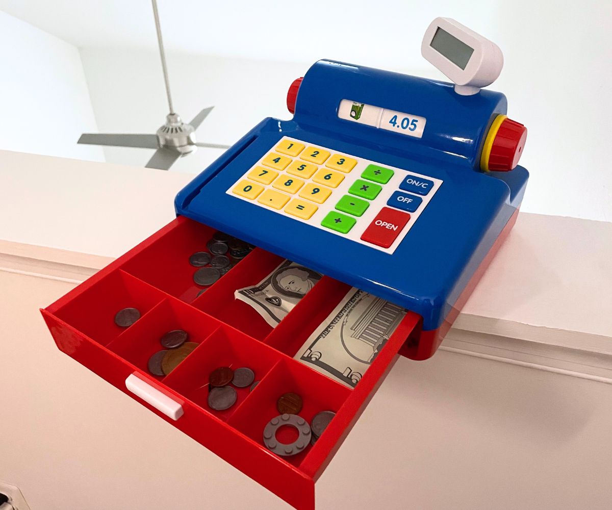 primary color cash register in blue, yellow, red, and green, opened with pretend money inside