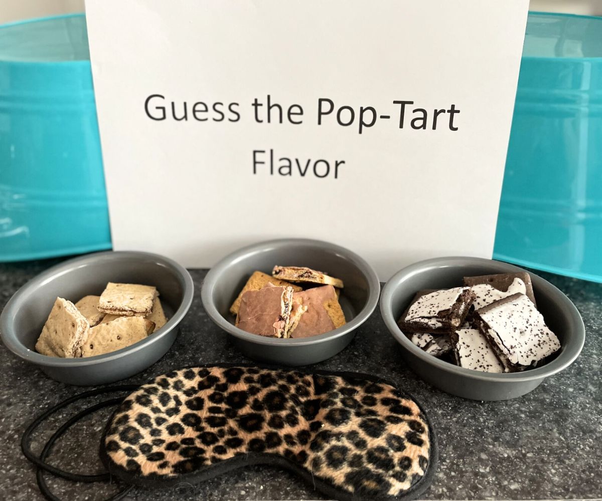 "Guess the Pop-Tart Flavor" blind taste test set up on counter with blindfold, and three bowls of different pieces of Pop-Tarts