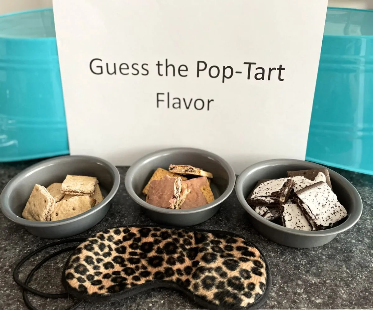"Guess the Pop-Tart Flavor" blind taste test set up on counter with blindfold, and three bowls of different pieces of Pop-Tarts