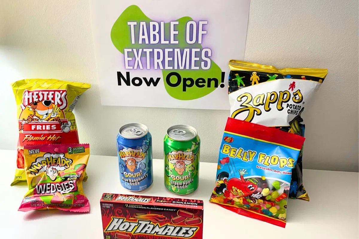 Table of Extremes sign with lots of spicy and sour tasting snacks from Dollar Tree