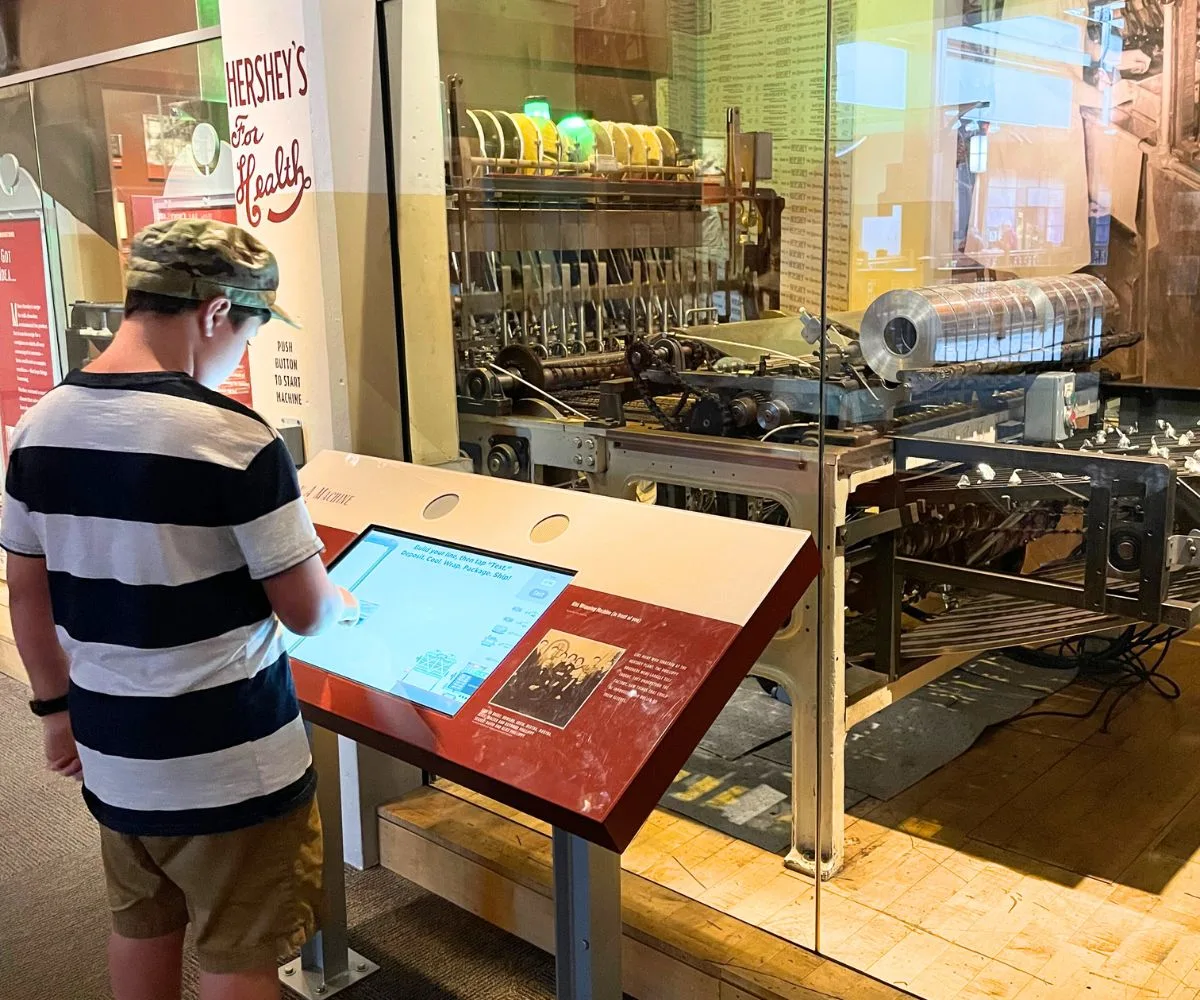 child pushing buttons to learn about factory process