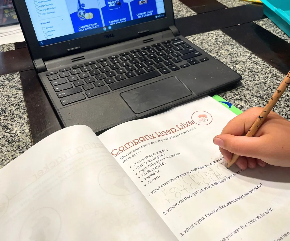 kid filling in Company Deep Dive worksheet on Cadbury Company