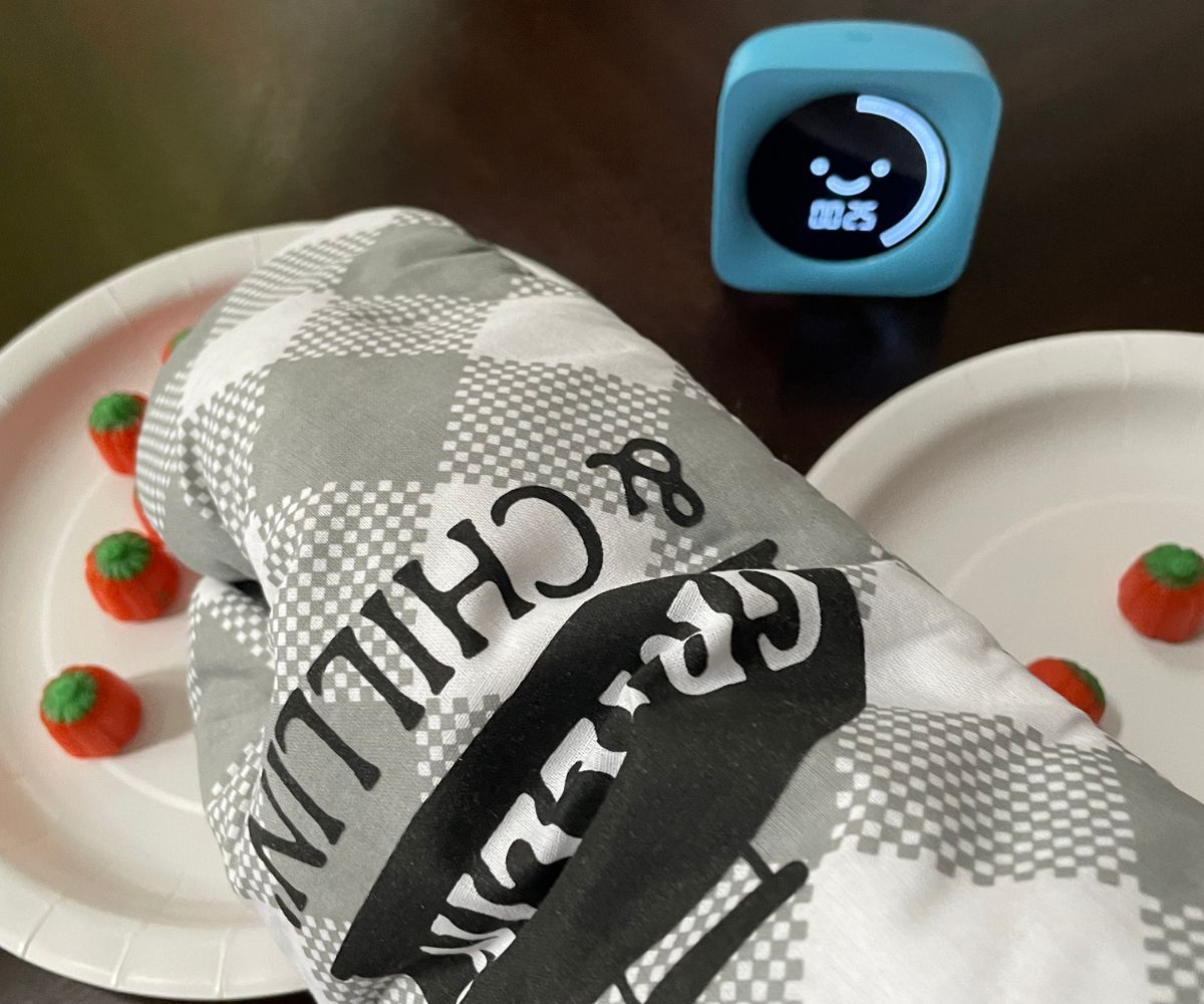 hand in oven mitt trying to pick up one pumpkin candy at a time, with 25 seconds left