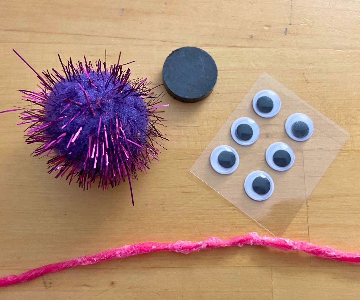 small pouf, pink wikki stix, craft eyeballs, and a magnet