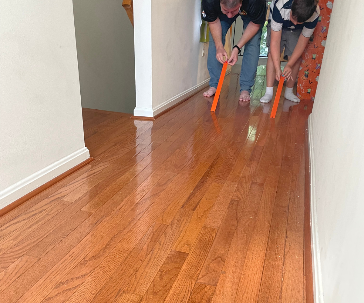 man and kid set up to release gumball down their own Hot Wheels race track