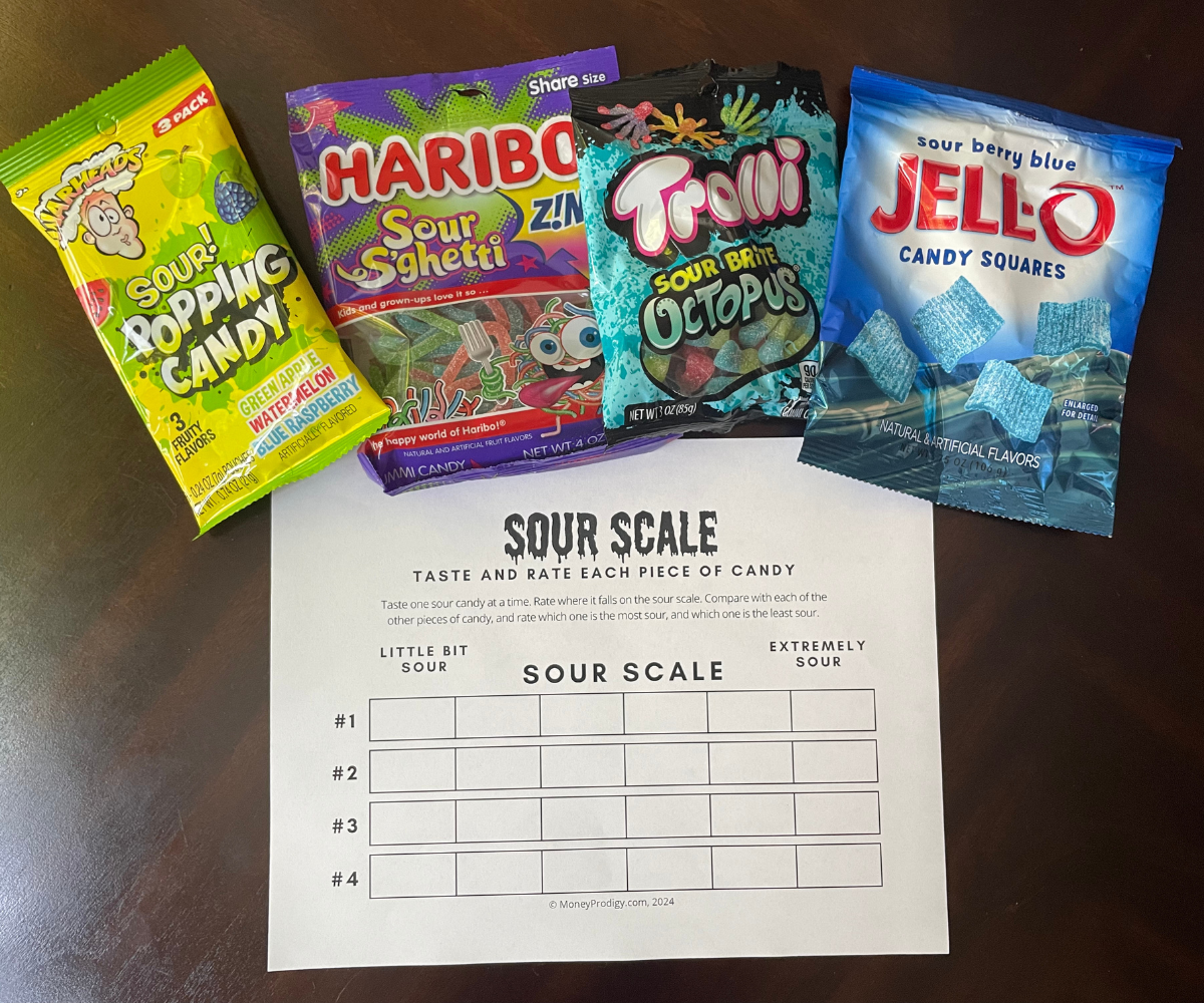 four types of sour candies with free printable Sour Scale on dark table