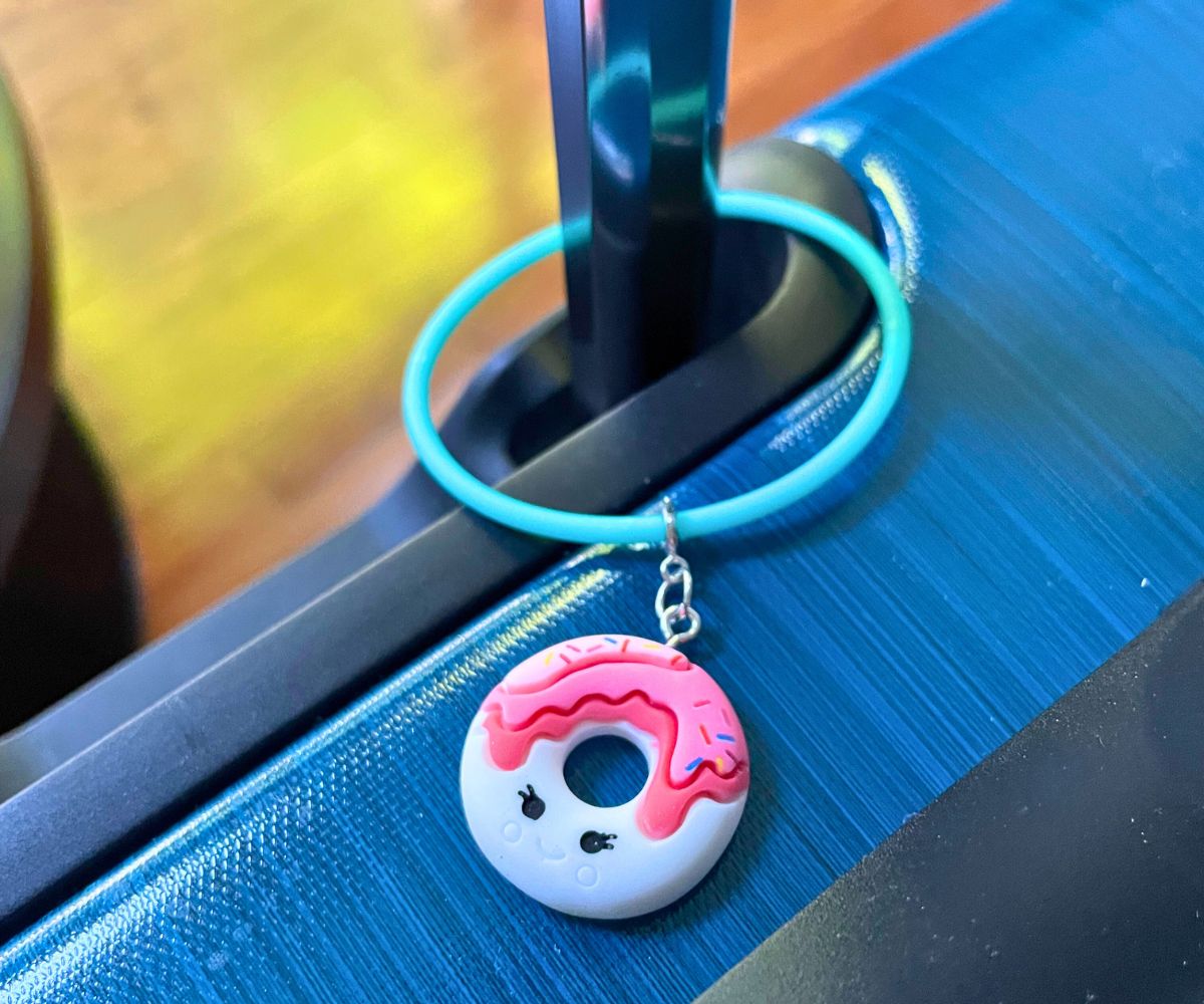 blue suitcase with new luggage tag with cute donut charm