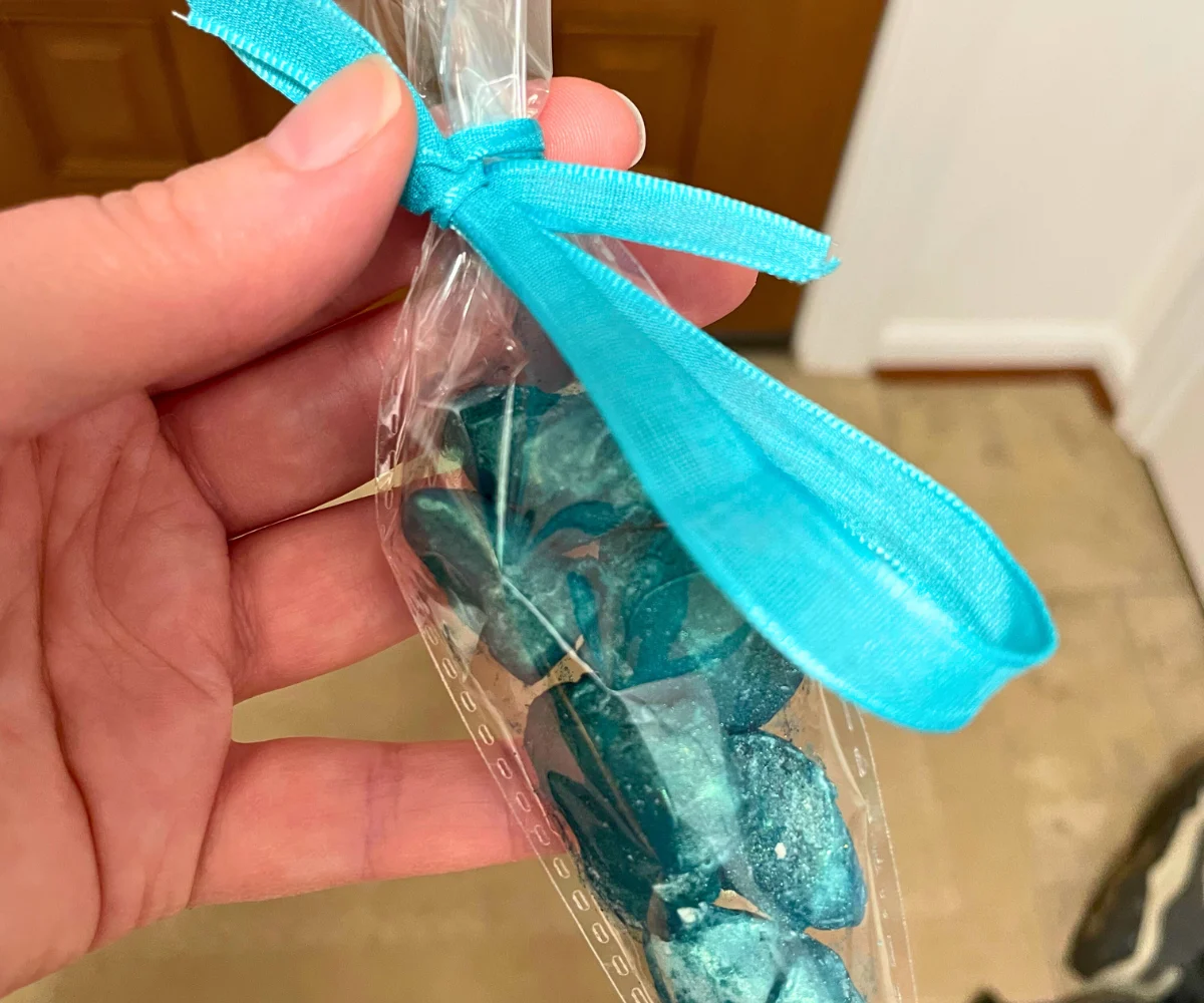 hand holding cone with gorgeous, sparkly teal gemstone rocks (almonds with candy melt and edible glitter on them)