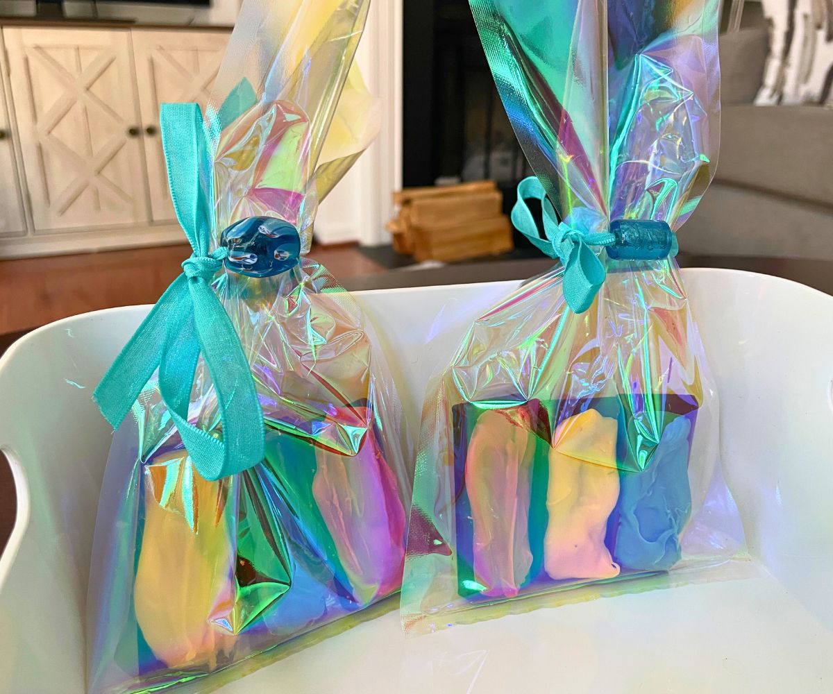 two rainbow chocolate half-bars in two packages with beautiful blue glass bead tied around front