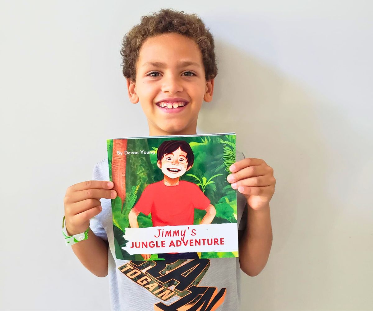 7-year-old Devon holding up his book and smiling