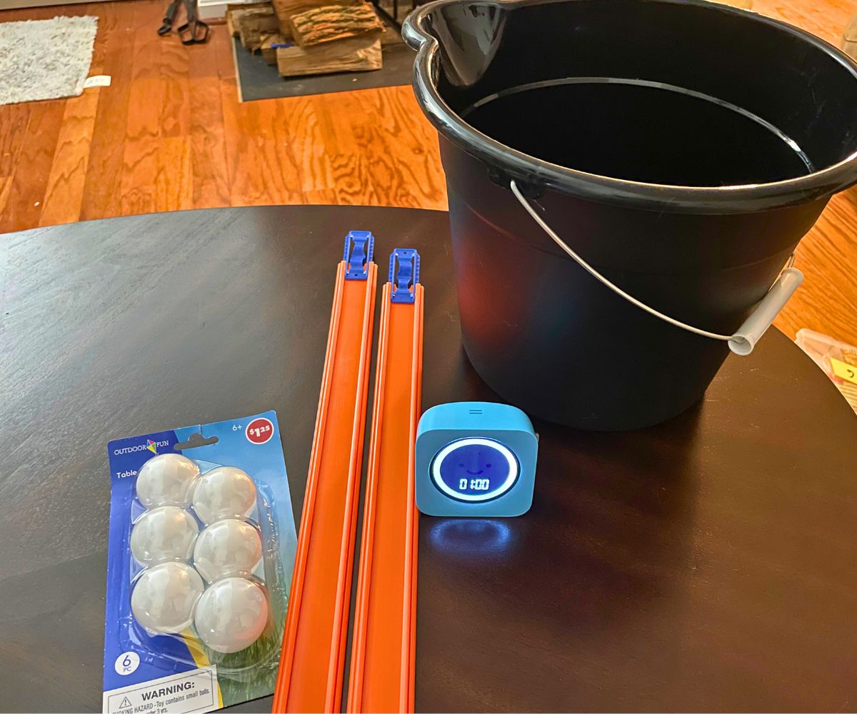 black bucket, two car tracks, ping pong balls, and a timer