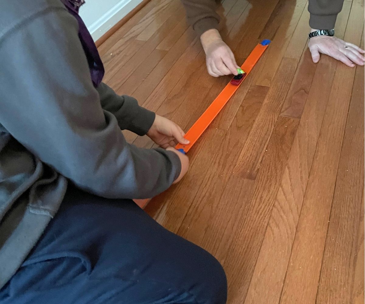 two people building out the race track and transporting the candy in the Hot Wheels with timer