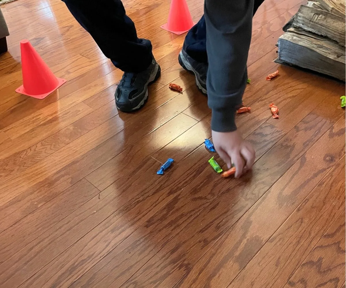 tween between safety cones bouncing the ball and picking up piece of candy off the floor