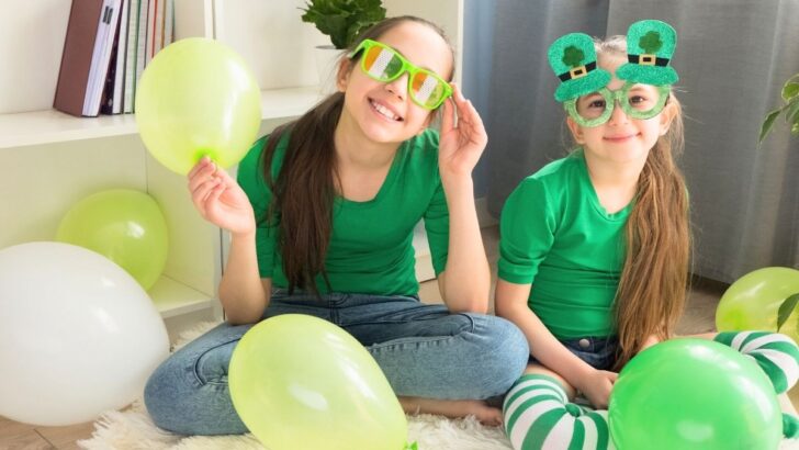 two girls in funny green glasses, green shirts, playing leprechaun St. Patricks games