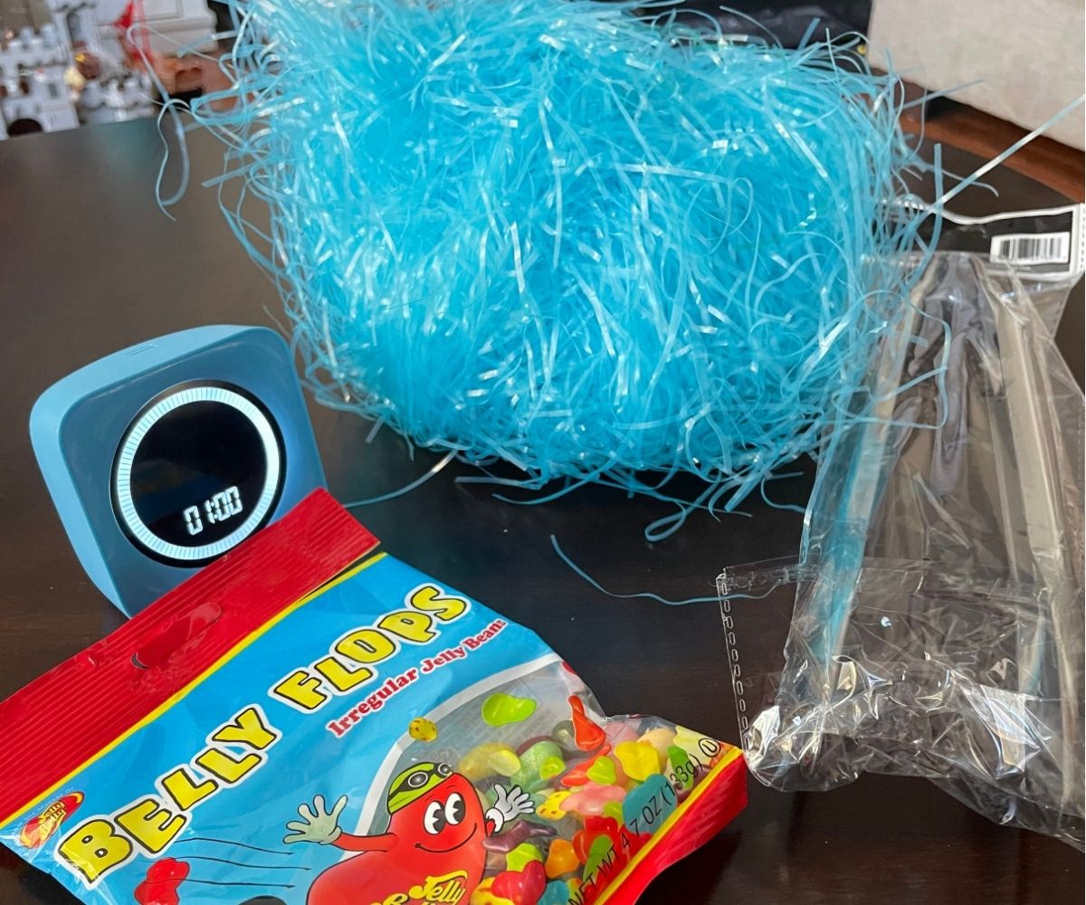 Jelly Belly flops beans, silver tongs, bright blue Easter grass, and a one-minute timer