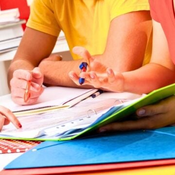 three teens in brightly colored shirts working on budgeting printables