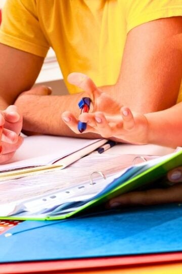 three teens in brightly colored shirts working on budgeting printables