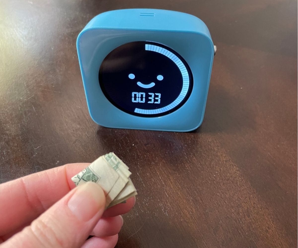 dollar bill folded down very small with timer showing 33 seconds left