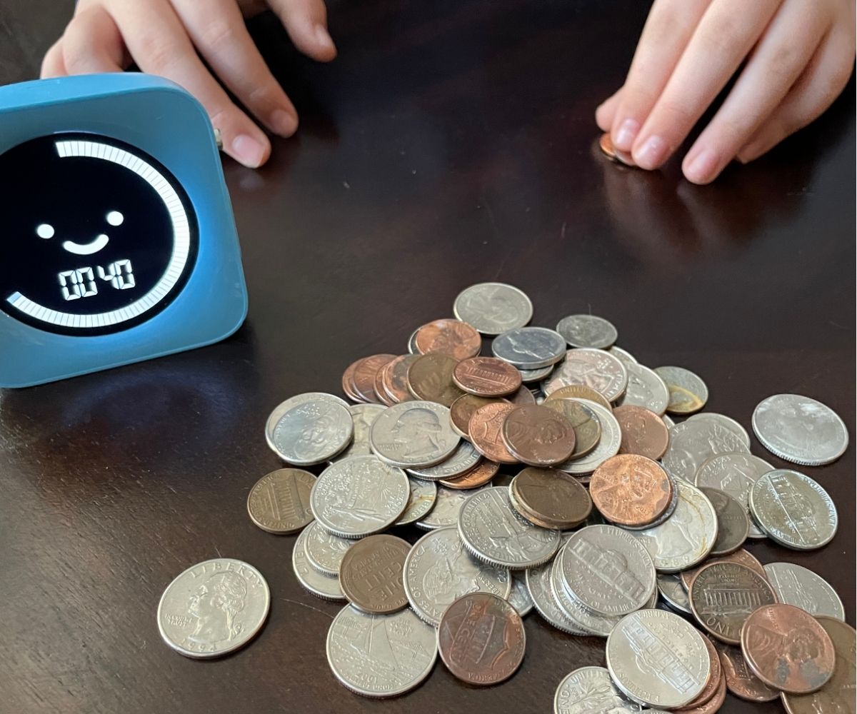 tween's hands feeling for pennies in a pile of coins, with timer showing 40 seconds left