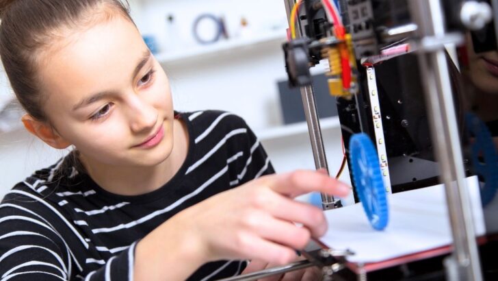 girl student in striped shirt at 3D printer