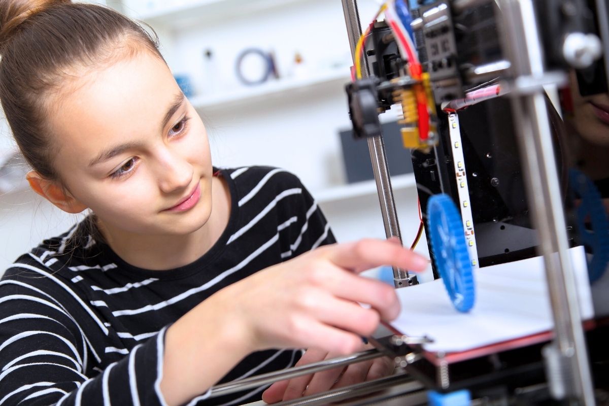 girl student in striped shirt at 3D printer