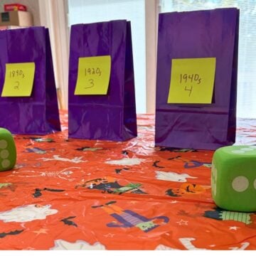 bright orange Halloween tablecloth with purple bags on it and big green dice
