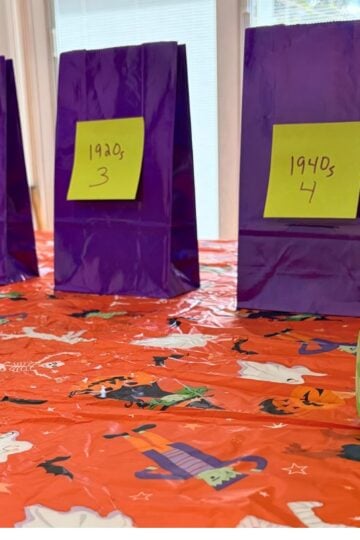 bright orange Halloween tablecloth with purple bags on it and big green dice