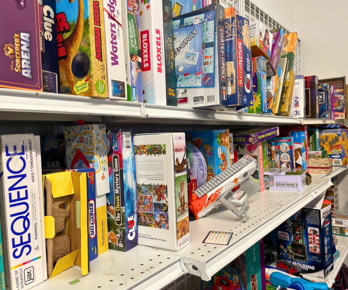 three shelves at thrift store stuffed with used board games