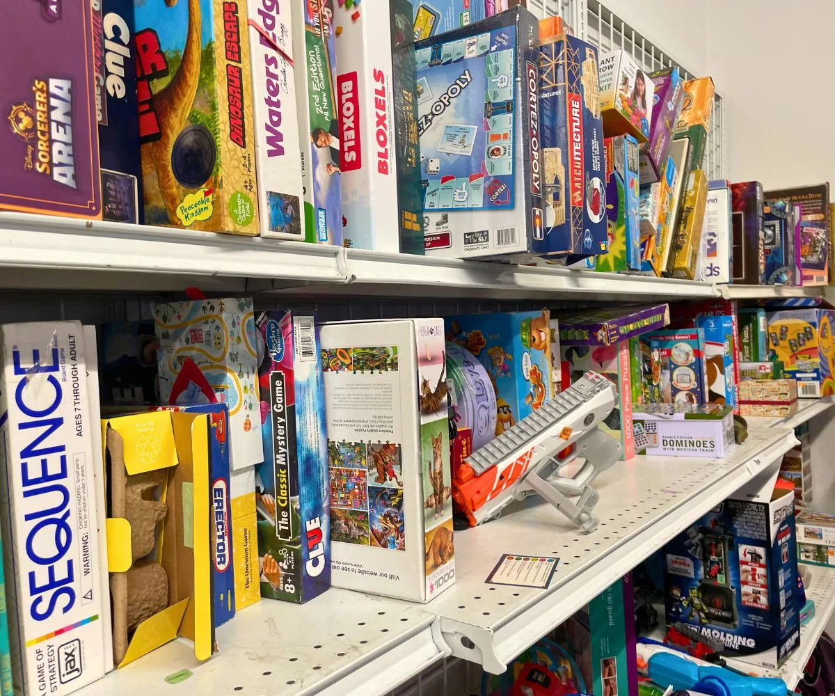 three shelves at thrift store stuffed with used board games