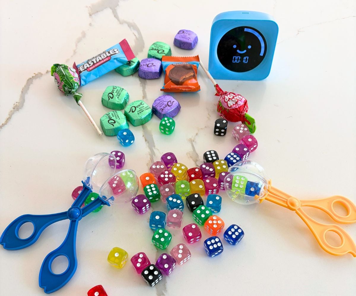 a bunch of candy, and a bunch of colored dice, a timer set to 10 secs. and two bug catchers opened up with dice in them
