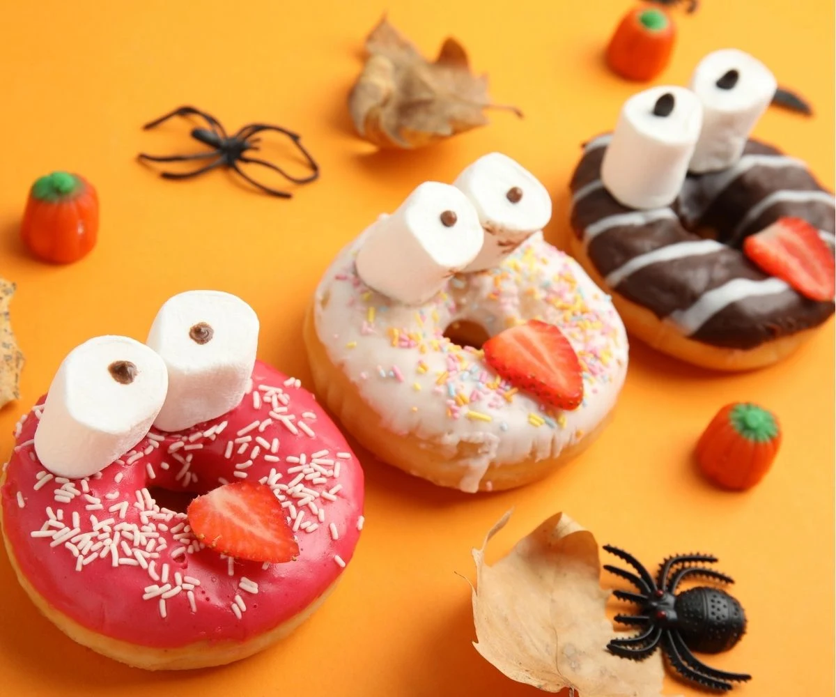 three donuts with two marshmallow for yees and a strawberry slice for tongues